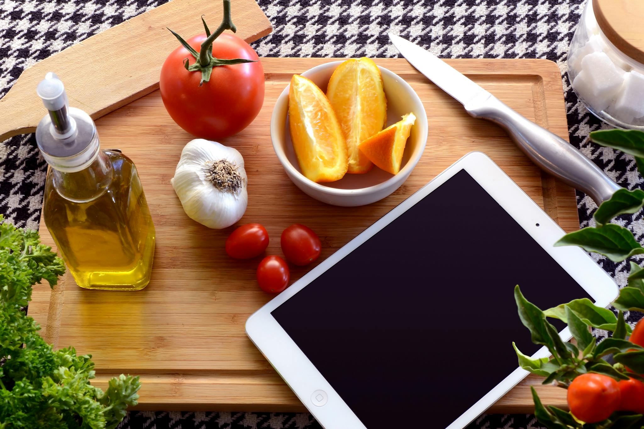 Top view of fresh ingredients and a tablet on a cutting board, perfect for a cooking theme.